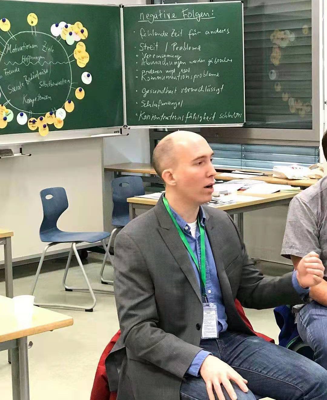 Ryan Scott Ulrich leading a classroom session, seated with participants in front of chalkboards
